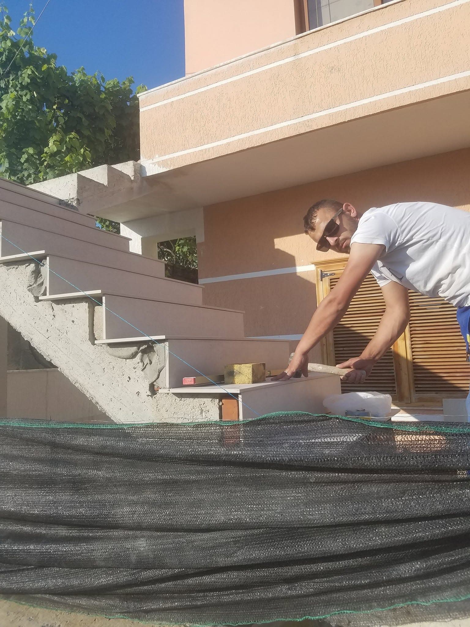 Arben Dehari laying tiles on a Dehari Construction project